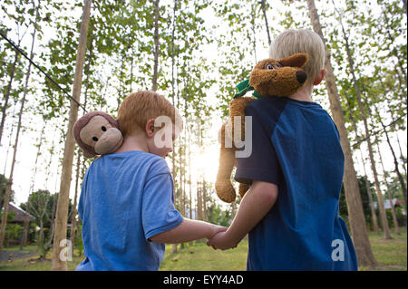 Fratelli caucasici che trasportano animali imbalsamati all'aperto Foto Stock
