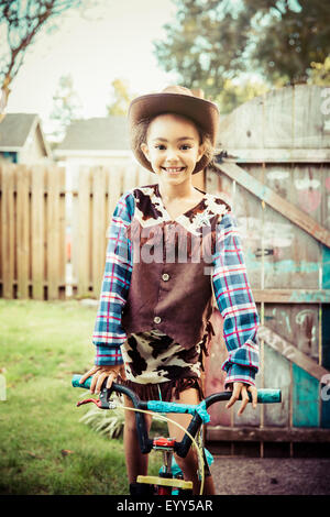Razza mista ragazza indossando il costume da cowboy in cortile Foto Stock