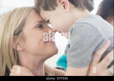 Close up di soggetti di razza caucasica la madre e il figlio di toccare la fronte Foto Stock