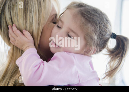 Close up di madre caucasica kissing figlia Foto Stock