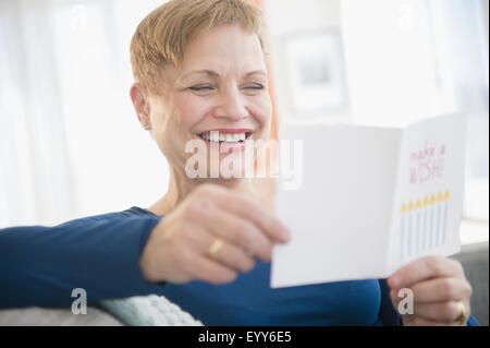 La donna caucasica la lettura di biglietto di auguri di compleanno Foto Stock