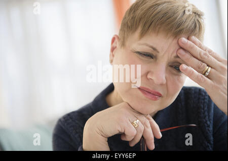 Ansiosa donna caucasica fronte di sfregamento Foto Stock