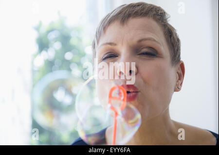 Ravvicinata di una donna caucasica soffiare bolle Foto Stock