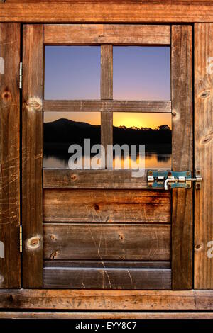 La porta di legno con finestra al tramonto e il fiume Foto Stock