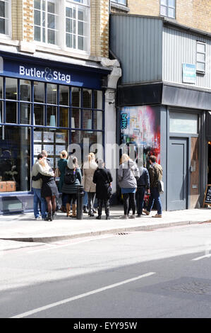 Una guida turistica con un gruppo di turisti a piedi intorno al Brick Lane, Shoreditch area di East London guardando i pezzi di graffiti Foto Stock