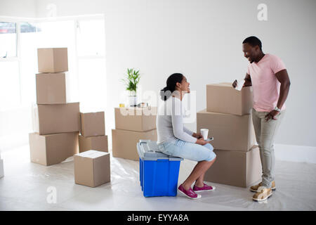 Coppia con scatole di cartone nella nuova casa Foto Stock