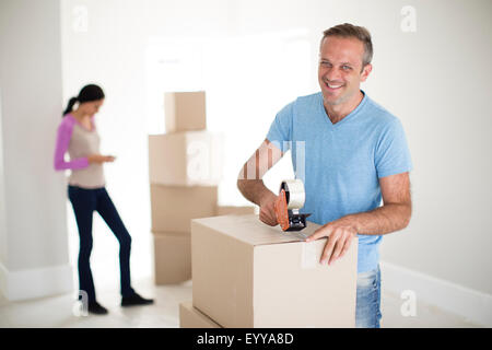 L'uomo la nastratura scatola di cartone per spostare Foto Stock