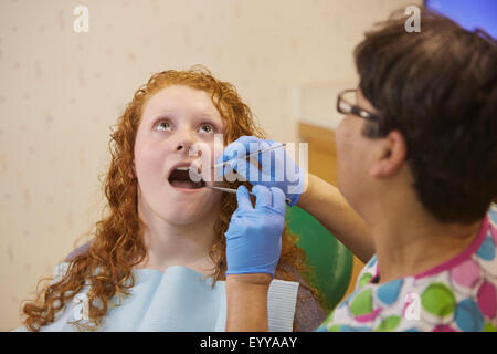 Dentista pediatrico esaminando denti del paziente adolescente Foto Stock