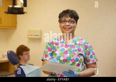 Dentista pediatrico sorridente in ufficio Foto Stock