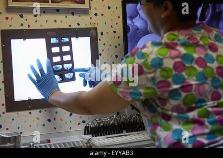 Dentista pediatrico esaminando i raggi x in office Foto Stock