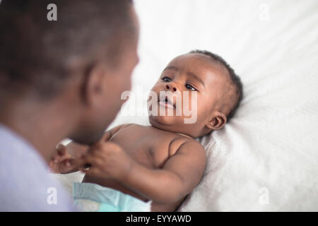 Chiusura del padre nero giocando con il bambino sul letto Foto Stock