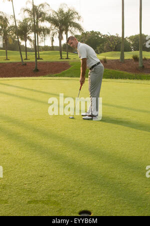 Uomo caucasico mettendo sul campo da golf Foto Stock
