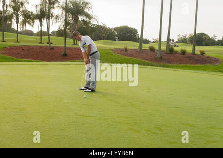 Uomo caucasico mettendo sul campo da golf Foto Stock