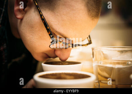 Caucasian barista odore di caffè in tazza Foto Stock