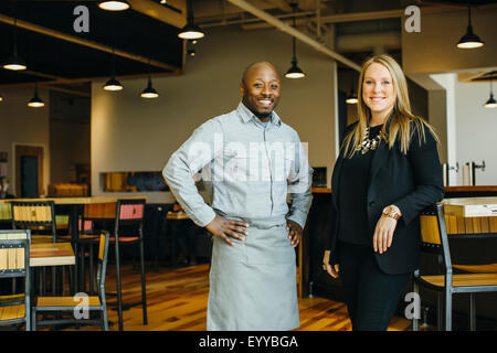 Cameriere e imprenditrice sorridente in cafe Foto Stock