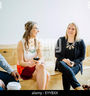 Imprenditrici parlando nella lobby di office Foto Stock