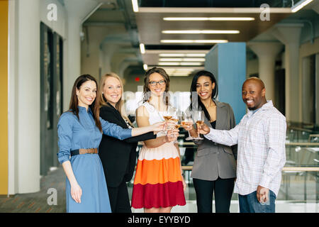 La gente di affari la tostatura con vino in ufficio Foto Stock