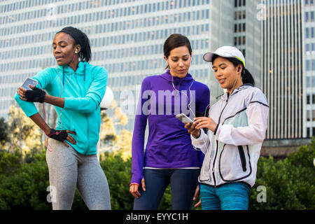 Pattini con il telefono cellulare vicino a edifici alti Foto Stock