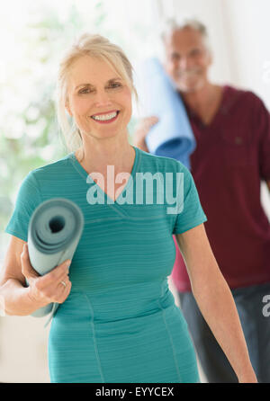 I vecchi Caucasian giovane che trasportano Materassini da yoga Foto Stock