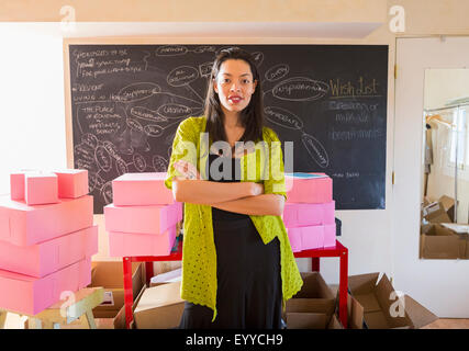 Razza mista imprenditrice in piedi in ufficio Foto Stock