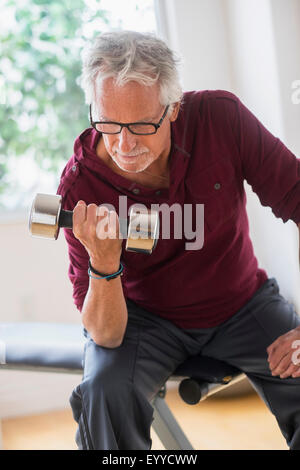 Vecchio uomo caucasico sollevamento pesi nella palestra Foto Stock