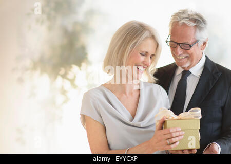 Sorridente vecchio uomo caucasico dando moglie un regalo Foto Stock