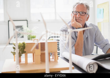 I vecchi architetto caucasica esaminando il modello in scala in ufficio Foto Stock