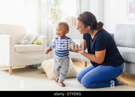 Razza mista madre giocando con il bambino figlio nel soggiorno Foto Stock