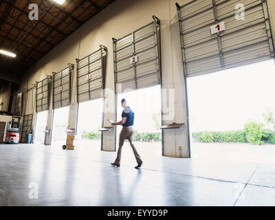 Vista offuscata del lavoratore caucasica camminando in magazzino Foto Stock