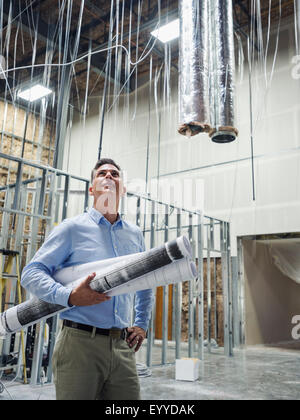 Architetto caucasici che trasportano blueprint al sito in costruzione Foto Stock