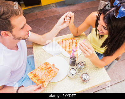 Ispanico giovane mangiare la pizza al cafe Foto Stock