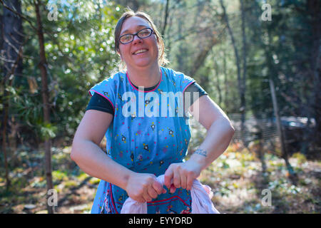 La donna caucasica il lavaggio della biancheria in foresta Foto Stock