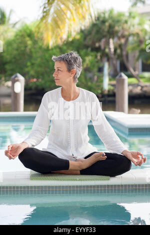 Donna meditando ancora da piscina Foto Stock