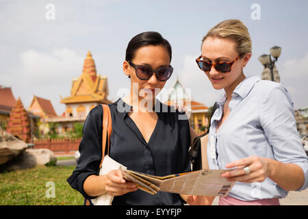 I turisti la lettura mappa vicino tempio, Phnom Penh Cambogia Foto Stock