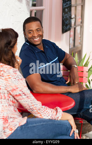 Giovane parlando a sidewalk cafe Foto Stock