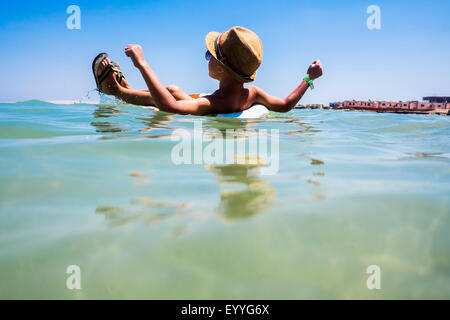 Mari boy galleggianti in anello gonfiabile in ocean Foto Stock