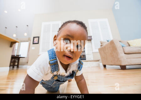 Bambino nero strisciando sul soggiorno piano Foto Stock