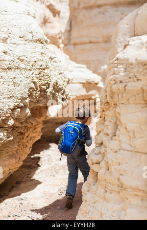 Ragazzo caucasico ad esplorare il deserto formazioni di roccia Foto Stock