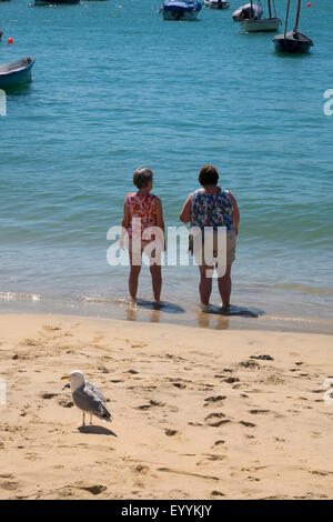 Due donne paddling in mare a St Ives, Cornwall, Regno Unito Foto Stock