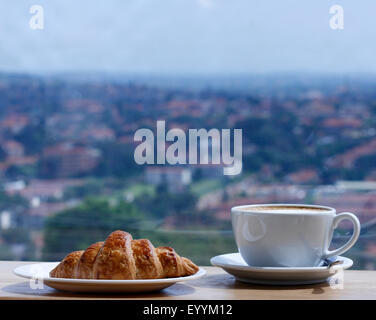 Un cappuccino e un cornetto con una vista Foto Stock