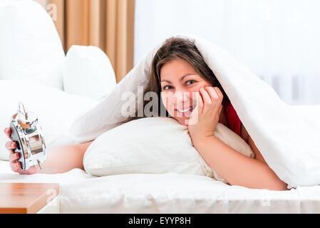 Donna con una sveglia e un buon inizio della giornata Foto Stock