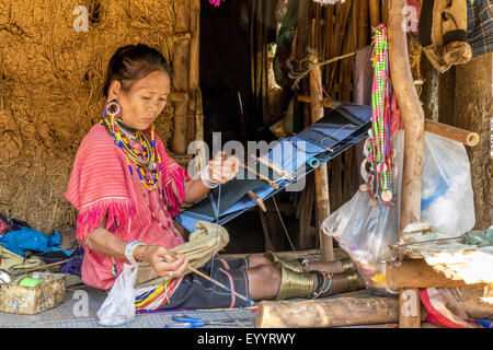 Donna della tribù Palong con abbigliamento tradizionale funziona con un telaio di tessitura, Thailandia Chiang Rai Foto Stock