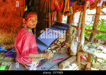 Donna della tribù Palong con abbigliamento tradizionale funziona con un telaio di tessitura, Thailandia Chiang Rai Foto Stock