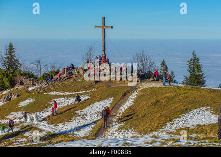 Croce sulla cima del monte nella luce del sole e la nebbia nella valle, in Germania, in Baviera, Kampenwand, Hohenaschau Foto Stock