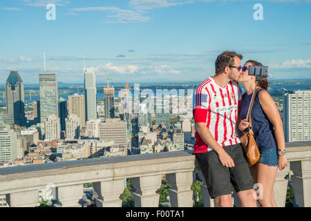 Coppia giovane usando un bastone selfie nella parte anteriore della Skyline di Montreal, Kondiaronk belvedere. Foto Stock