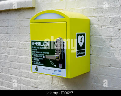 Defibrillatore cardiaco di salvataggio Attrezzature per arresto cardiaco con il blocco di codice per uso pubblico in un villaggio in Inghilterra, Regno Unito Foto Stock