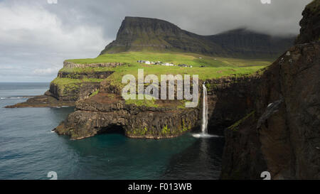 La cascata Mulafossur e il villaggio di Gasadalur. Funzionario Ministeriale isola. Isole di Faroe Foto Stock