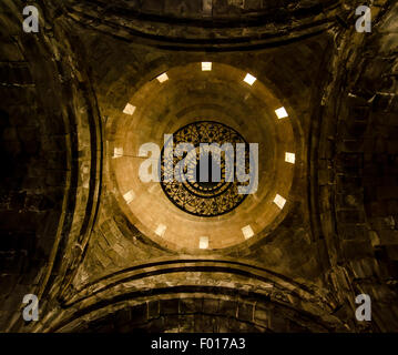 La bellezza architettonica di un antico monastero che presenta intricati lavori in pietra ed elegante lampadario Foto Stock