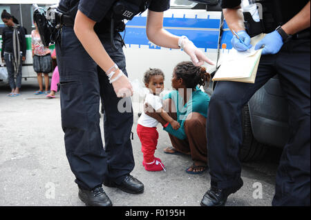 Rosenheim, Germania. 04 Ago, 2015. Mihert dall Eritrea e sua figlia di Tarik attendere per essere portato in un ufficio del tedesco della Polizia Federale presso la stazione ferroviaria di Rosenheim, Germania, 04 agosto 2015. La polizia tedesca prelevati circa 150 rifugiati provenienti da vari paesi in un treno in arrivo da Verona. Dopo aver cercato e registrati hanno ricevuto un documento di identificazione presso un ufficio del tedesco della polizia federale e sono stati inviati al rifugiato struttura di accoglienza di Monaco dove essi possono chiedere asilo. Foto: ANDREAS GEBERT/dpa/Alamy Live News Foto Stock