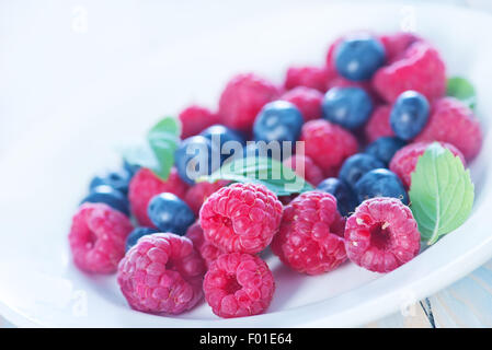 Frutti di bosco freschi sulla piastra e su una tavola Foto Stock